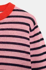 Jersey de punto de cuello redondo y manga larga con puños ajustados. Presenta un diseño de rayas horizontales en tonos rosa, azul marino y detalles en rojo.