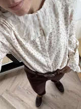 Camisa de algodón color crema con estampado de hojas marrones, cuello babero y puños de encaje.