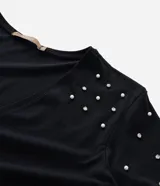 Blusa de algodón color blanco, con escote en V, manga corta y detalle de aplicación de strass en los hombros.