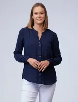 Blusa azul marino de gasa marca Zac & Rachel, con cuello a la base y escote en V. Manga larga regulable con presilla y botón. Aplique de puntilla en hombros.