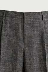 Pantalón de traje regular fit de la colección especial Aaron Levine x Zara, confeccionado en mezcla de lana y lino de color gris. Presenta diseño con pinzas delanteras, bolsillos laterales y traseros de doble vivo con botón, y cierre frontal con cremallera y gancho metálico oculto.