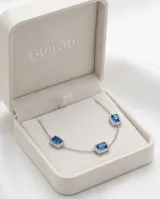 Pulsera de plata 925 con diseño de cadena fina y dije central rectangular con una circonia azul rodeada de pequeñas circonias blancas.