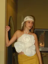 Top de corte halter color blanco, con diseño sin mangas y tres flores tridimensionales grandes aplicadas en el frente.