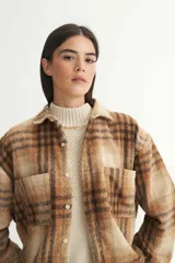 Sobrecamisa marrón a cuadros confeccionada en tela de algodón. Tiene cuello solapa clásico, bolsillos cuadrados en el pecho, botones personalizados y calce holgado.