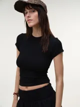 Remera negra de manga corta en tejido rib, de corte entallado y escote redondo.