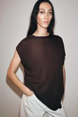 Top de punto color negro, con cuello redondo, manga corta y diseño asimétrico de corte fluido y caída en punta.