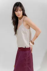 Top negro con rayas verticales blancas, escote en V y breteles finos regulables con detalle de borlas.