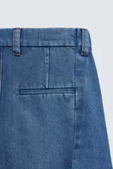 Bermuda de denim de algodón con corte relaxed fit, cintura con pliegues dobles en el delantero, bolsillos laterales y traseros de doble vivo, con efecto lavado y cierre frontal con cremallera y botón.