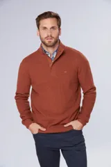 Buzo de tejido grueso color terracota con medio cierre frontal, cuello alto y puños acanalados. Presenta un diseño de textura tejida y un pequeño logo bordado en el pecho.