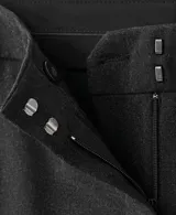 Pantalón de traje de tiro medio, color negro, de diseño recto y largo, con cierre frontal de cremallera, botón y ganchos ocultos con tapeta, y bolsillos laterales.