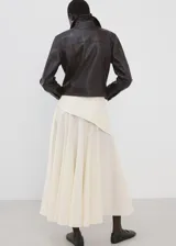 Falda larga color beige de algodón, con diseño evasé, tiro medio, forro interior y detalle cruzado tipo pañuelo con cierre de nudo en la cintura.