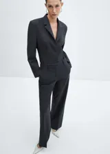Body con diseño de blazer entallado, confeccionado en tejido mezcla de lana. Presenta cuello con solapas de muesca, cierre frontal con botones, manga larga y detalle de pinzas delanteras y traseras.