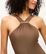 Malla enteriza marrón con escote halter cruzado y detalle metálico dorado en el frente.