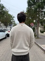 Sweater de tejido de punto en color beige, con cuello redondo y diseño de corte regular.