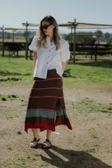 Pollera midi tejida en hilado 100% algodón, color marrón con rayas horizontales en tonos rojo y verde.