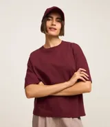 Blusa básica de mujer color negro, confeccionada en malla encorpada de algodón, con cuello redondo y mangas cortas de corte oversized con sisas desplazadas.