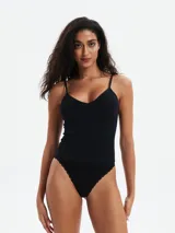 Musculosa negra de tejido acanalado, con escote en V y tirantes finos.