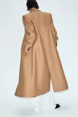 Abrigo largo negro ZARA Woman Collection de corte recto, confeccionado con hilatura de lana. Presenta cuello con solapa de muesca, cierre cruzado de doble botonadura frontal y bolsillos ribeteados en los laterales.