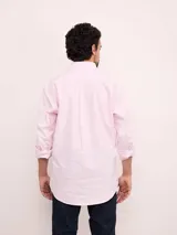 Camisa de corte regular confeccionada en algodón, con diseño de rayas verticales en tonos azul y blanco. Presenta cuello con botones, cierre frontal abotonado, bolsillo en el pecho con logo bordado y mangas largas.