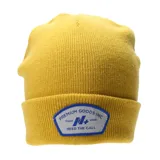 Gorro tipo beanie tejido en color amarillo, con vuelta y parche frontal rectangular con bordes redondeados en color gris, con inscripciones y logo en azul.