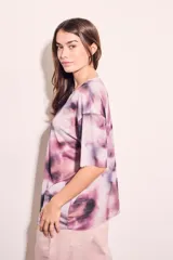 Remera oversize de tul con estampado abstracto en tonos rosa, lila y negro.