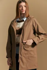 Pilot de largo medio color azul marino, con capucha integrada, cierre frontal oculto y bolsillos aplicados con tapa. Presenta una silueta recta y diseño funcional.