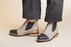 Botas Chelsea de cuero color visón con puntera negra, elástico lateral negro y suela de madera.