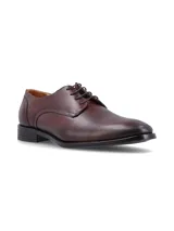 Zapato de vestir tipo derby color café, confeccionado en cuero con cierre de cordones y suela de goma con costura vista.