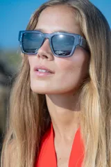 Lentes de sol Vulk modelo Register, de industria argentina, con armazón cuadrado de acetato celeste translúcido y lentes polarizadas grises.