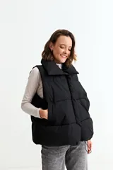 Chaleco puffer de corte holgado y diseño acolchado, con cuello alto y cierre frontal oculto. Presenta cordón ajustable en el ruedo inferior y bolsillos laterales.