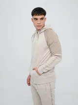 Campera canguro deportiva Umbro para hombre, de color verde militar con mangas negras de diseño raglán y detalles en verde militar. Cuenta con cierre frontal completo, capucha con cordones ajustables y bolsillos estilo canguro.