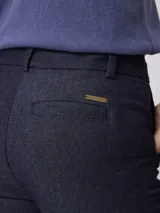 Pantalon sastrero de corte wide leg, color azul oscuro, con pinzas frontales, cierre de botón y bolsillos laterales.