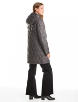 Campera matelassé color verde militar, con diseño de pespuntes en forma de ondas. Presenta cierre frontal completo, cuello alto, capucha fija acolchada y bolsillos laterales invisibles. Su corte es holgado y llega por debajo de la cadera.