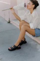 Sandalias de cuero marrón con plataforma de goma negra y hebillas metálicas.