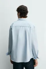 Camisa regular fit de color celeste, confeccionada en tejido con mezcla de algodón y seda, con cuello solapa, manga larga con puño abotonado y cierre frontal de botonadura.