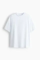 Remera en punto pesado de algodón con cuello redondo, mangas cortas y hombreras gruesas. Presenta un bajo recto con sutiles aberturas laterales.