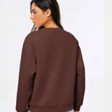 Buzo de cuello redondo y manga larga, confeccionado en tejido de punto fino con diseño liso y corte holgado.
