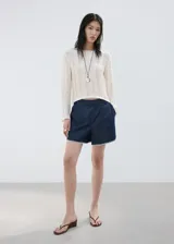 Short de denim azul oscuro de tiro alto, con bolsillos y detalle de bordado blanco en el borde inferior.