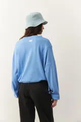 Buzo celeste cropped de manga larga con puños y cordones ajustables en la cintura.