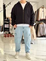 Campera tipo canguro con cierre frontal completa y capucha, de corte boxy fit en color blanco marfil. Presenta bolsillos frontales tipo parche y puños y dobladillo en rib elástico.