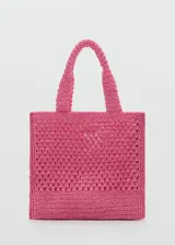 Bolso tipo shopper de tejido de fibra natural en color fucsia, con diseño de punto calado y asas cortas para llevar al hombro.