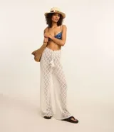 Pantalón de playa tejido al crochet color blanco, con cintura elastizada con lazo y borlas.