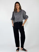 Pantalon negro de corte recto, con bolsillos laterales y cierre frontal.