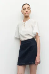 Minifalda de tweed color blanco con flecos en el ruedo.