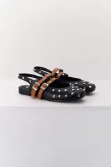 Balerina negra de cuero con punta fina y dos correas marrones con hebilla sobre el empeine. Decorada con tachas plateadas.
