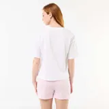 Pijama de dos piezas confeccionado en algodón, compuesto por una remera blanca de manga corta con estampado de Stitch y la frase 'You Make My Heart Smile', y un short rosado con finas rayas verticales blancas.