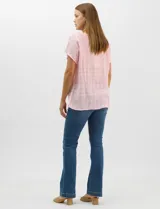 Blusa de corte fluido confeccionada en algodón con tejido texturizado de patrón a cuadros. Presenta mangas cortas caídas, escote redondo y cierre frontal con botones.