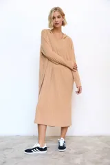 Vestido midi de lanilla color beige con capucha, confeccionado en tejido de punto morley acanalado, de manga larga y silueta holgada.