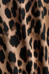 Body de manga larga con escote redondo, confeccionado en punto elástico con estampado de leopardo. Cuenta con refuerzo interior con botones a presión y frente forrado.