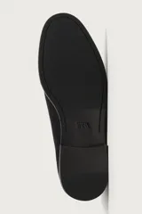Mocasín de vestir negro confeccionado en piel con acabado serraje, con detalle de borlas en el empeine y ligero tacón.